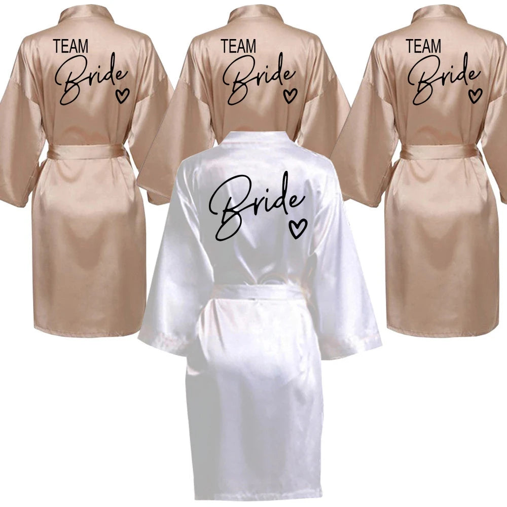 La robe kimono satinée “Wedding Party Team Bride Robe With Black Letters SP003” est un peignoir élégant pour mariée ou demoiselles d’honneur, avec inscription noire “Team Bride” au dos, idéal pour les enterreme