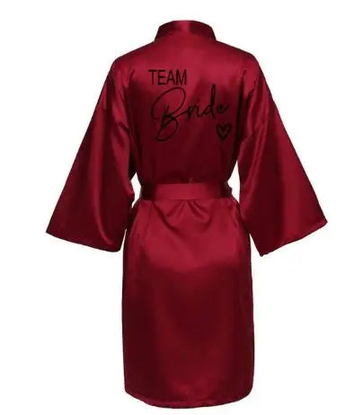 La robe kimono satinée “Wedding Party Team Bride Robe With Black Letters SP003” est un peignoir élégant pour mariée ou demoiselles d’honneur, avec inscription noire “Team Bride” au dos, idéal pour les enterreme