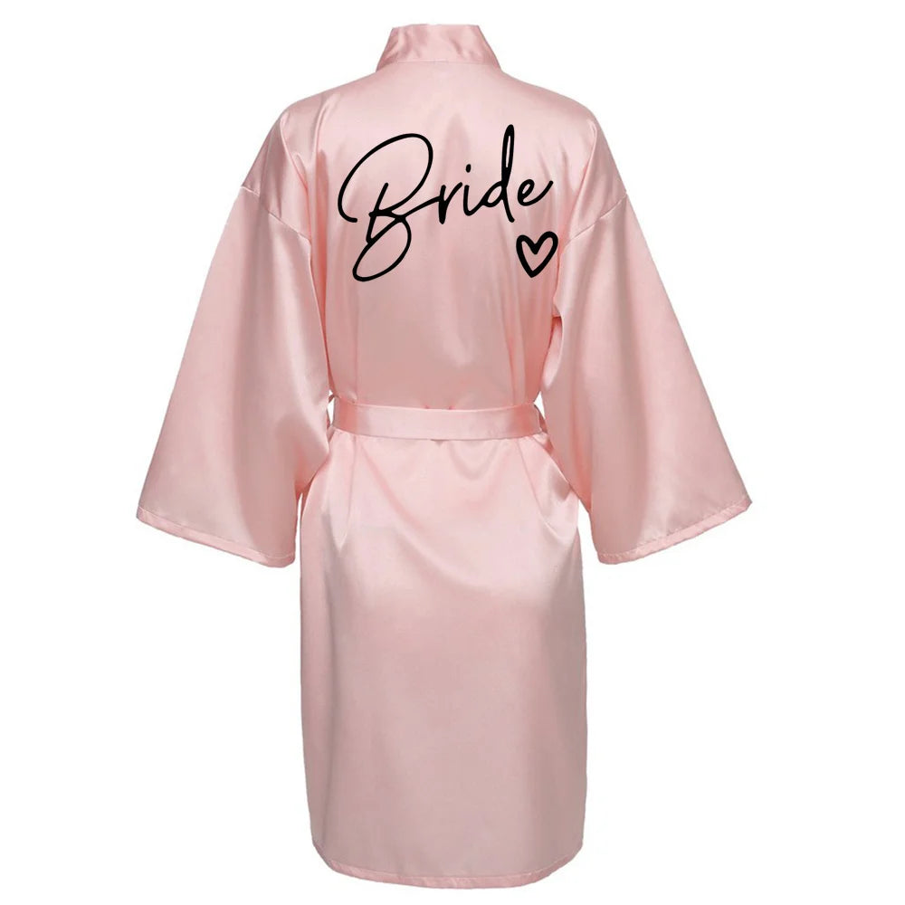 La robe kimono satinée “Wedding Party Team Bride Robe With Black Letters SP003” est un peignoir élégant pour mariée ou demoiselles d’honneur, avec inscription noire “Team Bride” au dos, idéal pour les enterreme