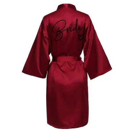 La robe kimono satinée “Wedding Party Team Bride Robe With Black Letters SP003” est un peignoir élégant pour mariée ou demoiselles d’honneur, avec inscription noire “Team Bride” au dos, idéal pour les enterreme