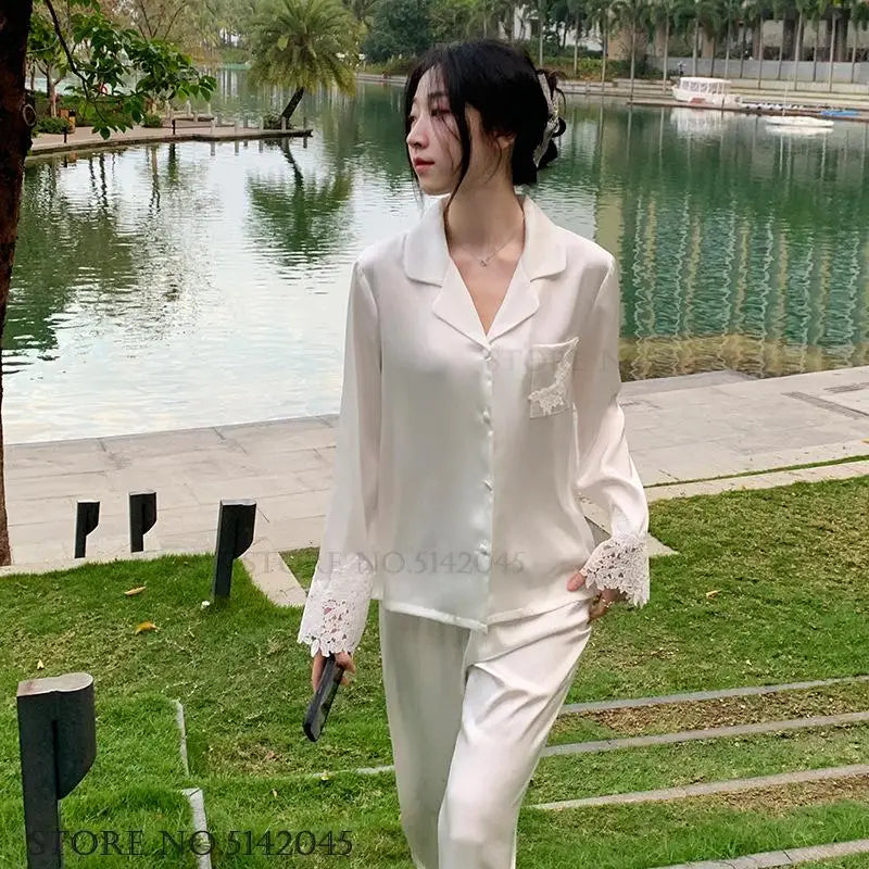 L’ensemble de pyjama de luxe pour femmes est une tenue de nuit élégante en satin soyeux blanc, ornée de dentelle, avec pantalon et haut amples pour un style casual et détendu à la maison.