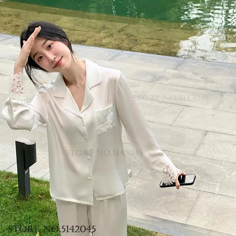 L’ensemble de pyjama de luxe pour femmes est une tenue de nuit élégante en satin soyeux blanc, ornée de dentelle, avec pantalon et haut amples pour un style casual et détendu à la maison.