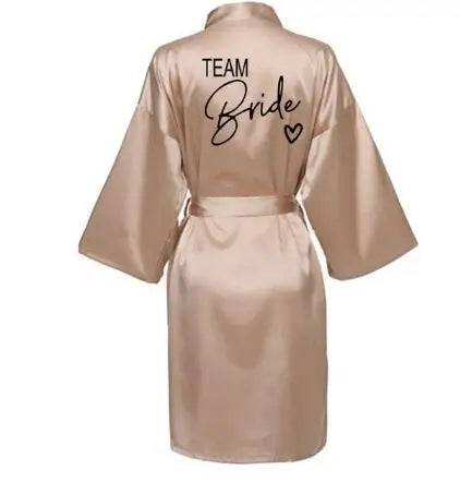 La robe kimono satinée “Wedding Party Team Bride Robe With Black Letters SP003” est un peignoir élégant pour mariée ou demoiselles d’honneur, avec inscription noire “Team Bride” au dos, idéal pour les enterreme