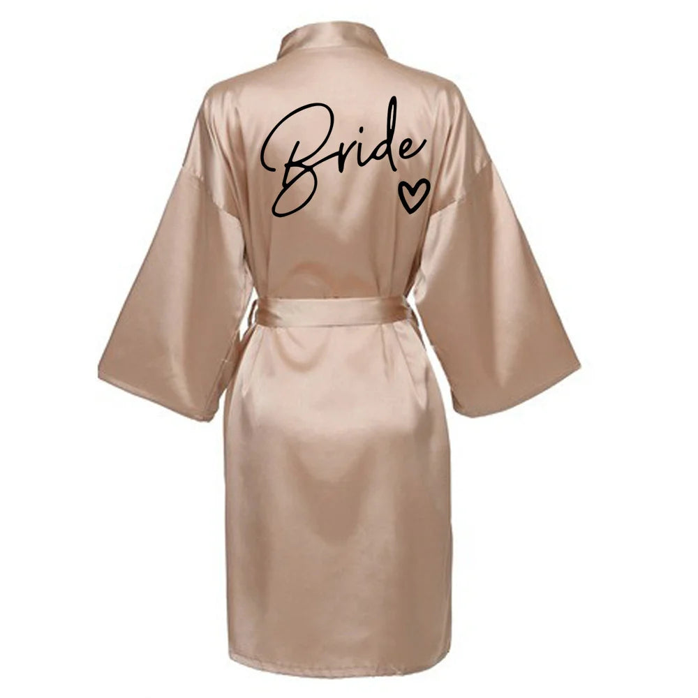 La robe kimono satinée “Wedding Party Team Bride Robe With Black Letters SP003” est un peignoir élégant pour mariée ou demoiselles d’honneur, avec inscription noire “Team Bride” au dos, idéal pour les enterreme