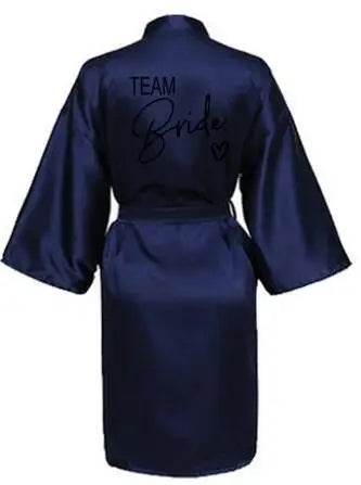 La robe kimono satinée “Wedding Party Team Bride Robe With Black Letters SP003” est un peignoir élégant pour mariée ou demoiselles d’honneur, avec inscription noire “Team Bride” au dos, idéal pour les enterreme