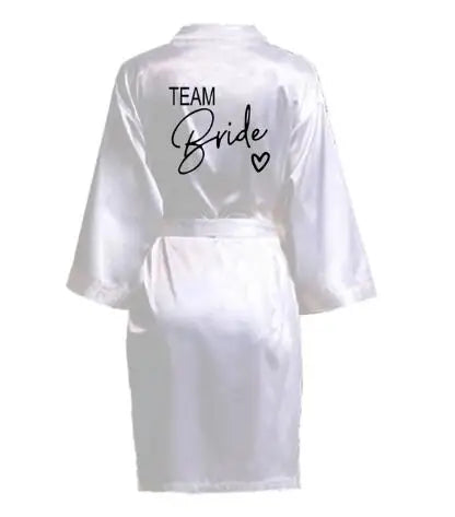 La robe kimono satinée “Wedding Party Team Bride Robe With Black Letters SP003” est un peignoir élégant pour mariée ou demoiselles d’honneur, avec inscription noire “Team Bride” au dos, idéal pour les enterreme
