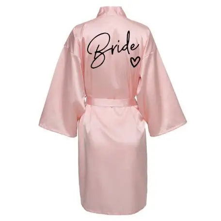La robe kimono satinée “Wedding Party Team Bride Robe With Black Letters SP003” est un peignoir élégant pour mariée ou demoiselles d’honneur, avec inscription noire “Team Bride” au dos, idéal pour les enterreme