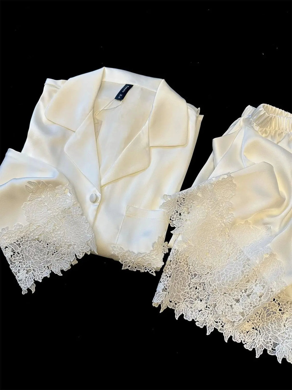 L’ensemble pyjama femme en satin soyeux est une tenue de nuit moderne et élégante, ornée de dentelle, idéale pour le sommeil ou la détente à la maison, avec un design fluide et féminin.