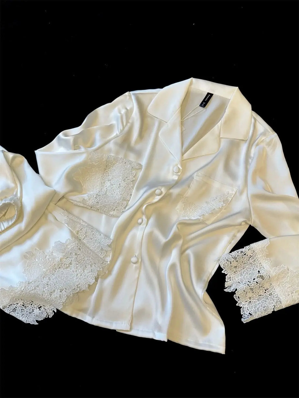 L’ensemble pyjama femme en satin soyeux est une tenue de nuit moderne et élégante, ornée de dentelle, idéale pour le sommeil ou la détente à la maison, avec un design fluide et féminin.